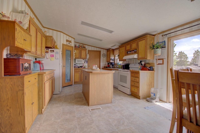 kitchen with a textured ceiling, a kitchen island, crown molding, and white appliances