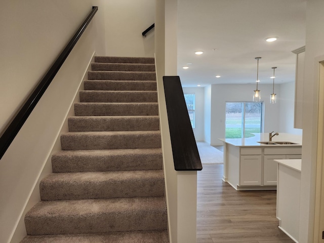 staircase with sink and hardwood / wood-style floors