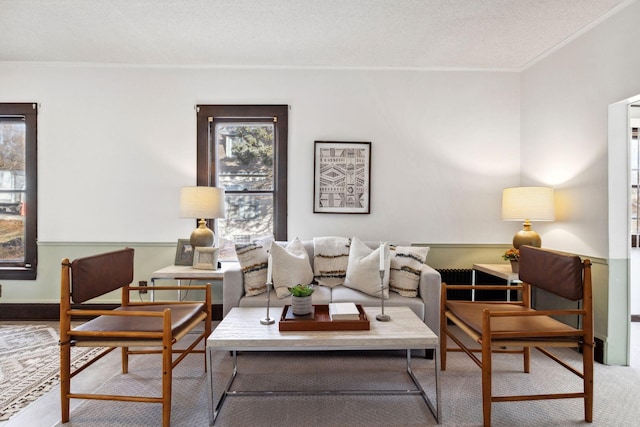 living room featuring ornamental molding, carpet flooring, and a textured ceiling