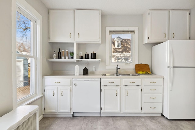 kitchen with white cabinetry, sink, and white appliances