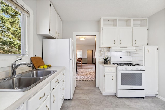 kitchen featuring sink, white cabinets, decorative backsplash, white appliances, and a textured ceiling