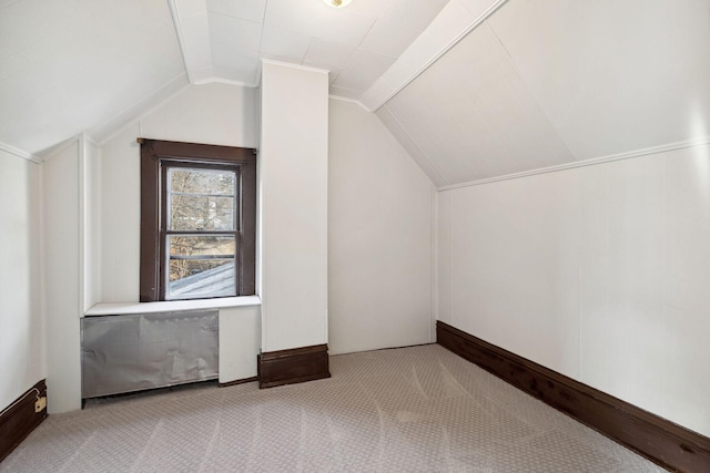 additional living space featuring vaulted ceiling and light colored carpet