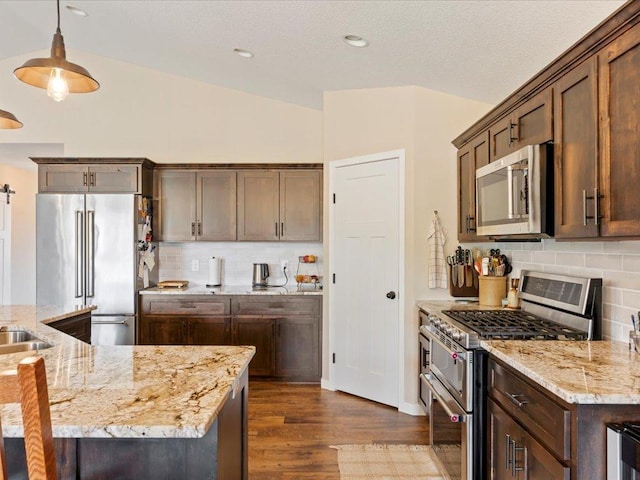 15104 Wild Ave, Brainerd, MN 56401 - kitchen featuring appliances with stainless steel finishes, vaulted ceiling, dark wood finished floors, backsplash, and light stone counters