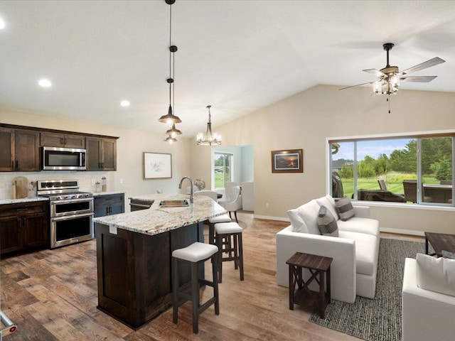 15104 Wild Ave, Brainerd, MN 56401 - kitchen with appliances with stainless steel finishes, dark brown cabinetry, a breakfast bar, open floor plan, and healthy amount of natural light
