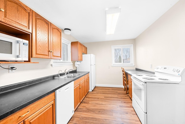 kitchen with white appliances, light hardwood / wood-style floors, and sink