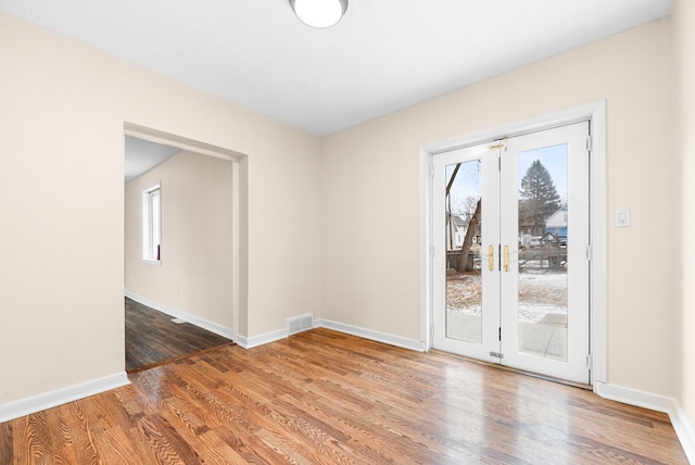 empty room featuring hardwood / wood-style flooring and french doors