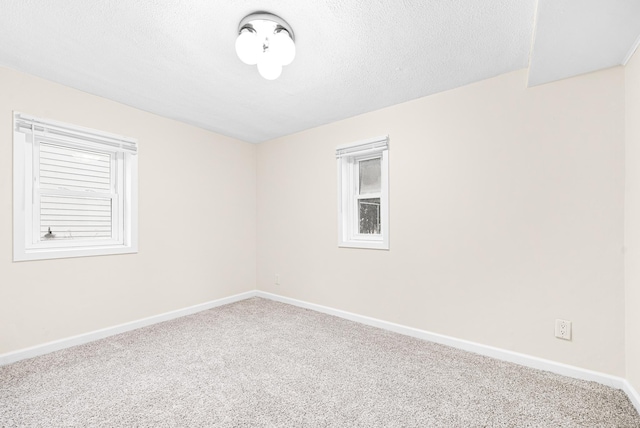 carpeted spare room featuring a textured ceiling