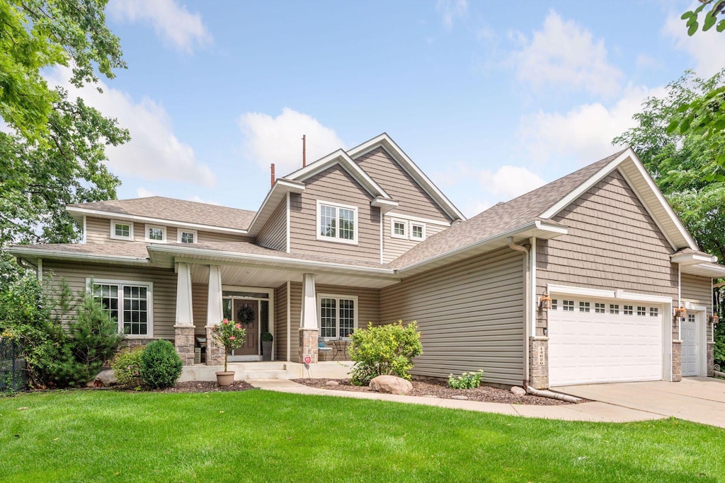 craftsman-style house featuring a porch, a garage, and a front yard