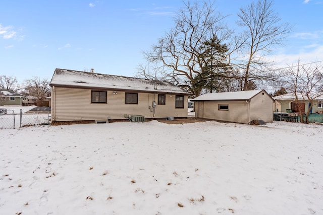 snow covered property featuring cooling unit and an outdoor structure