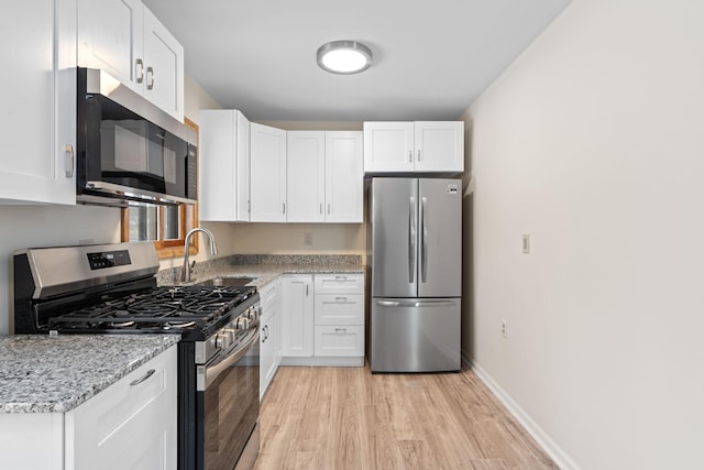 kitchen featuring appliances with stainless steel finishes, sink, and white cabinetry