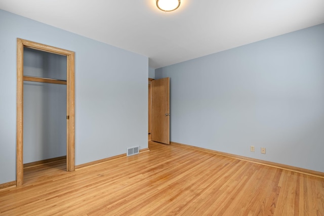 unfurnished bedroom with a closet and light hardwood / wood-style flooring