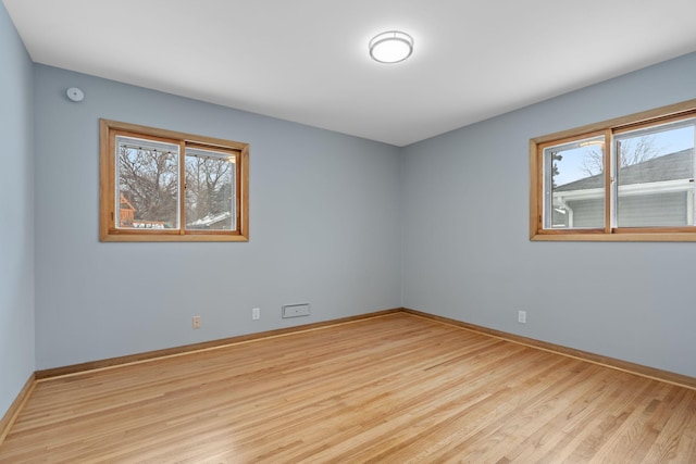 spare room with a wealth of natural light and light hardwood / wood-style flooring