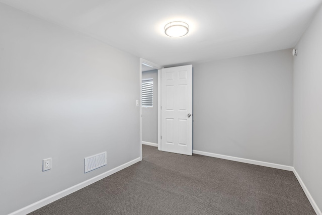 empty room featuring dark colored carpet