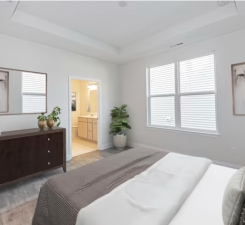 bedroom with connected bathroom and a raised ceiling