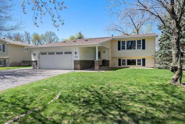 split level home with an attached garage, driveway, and a front yard