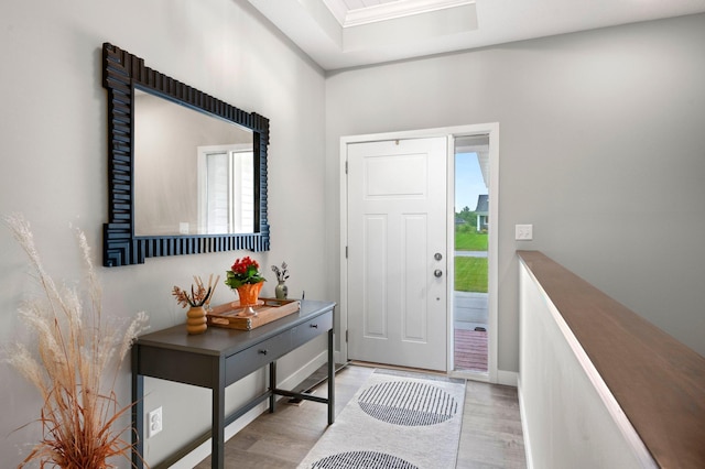 entryway featuring ornamental molding and light hardwood / wood-style floors