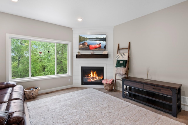 living room with a fireplace, plenty of natural light, and light hardwood / wood-style floors