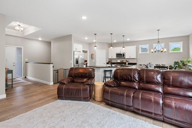 living room featuring light wood-type flooring and a notable chandelier