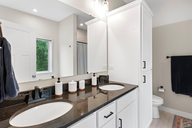 bathroom featuring vanity, hardwood / wood-style floors, and toilet