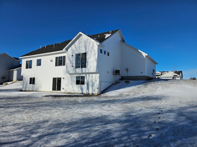 view of snow covered rear of property