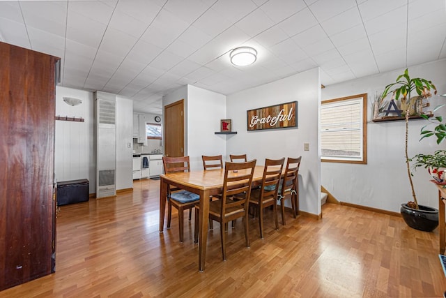 dining area with light wood-style flooring and baseboards