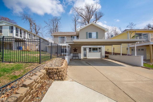 traditional home featuring a front lawn, fence, a carport, and driveway