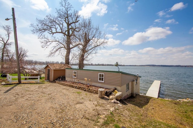 rear view of house featuring an outbuilding and a water view