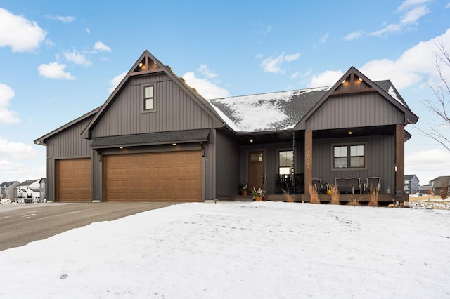 modern farmhouse featuring covered porch and a garage