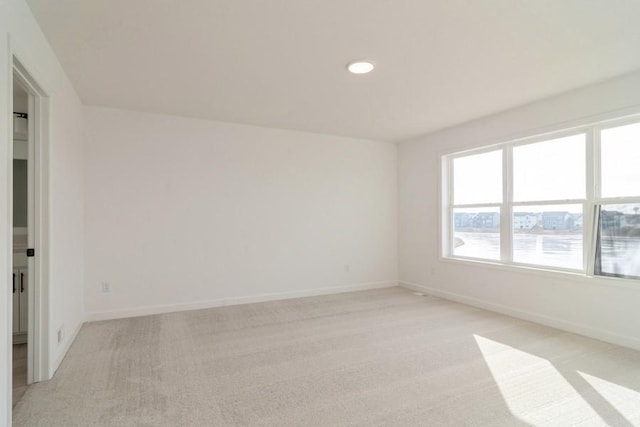 empty room with a water view and light colored carpet