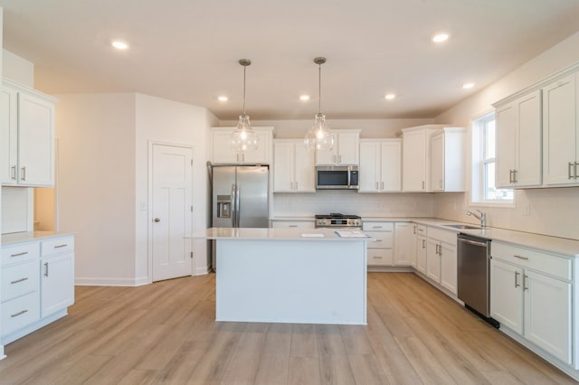 kitchen with stainless steel appliances, white cabinetry, and decorative light fixtures