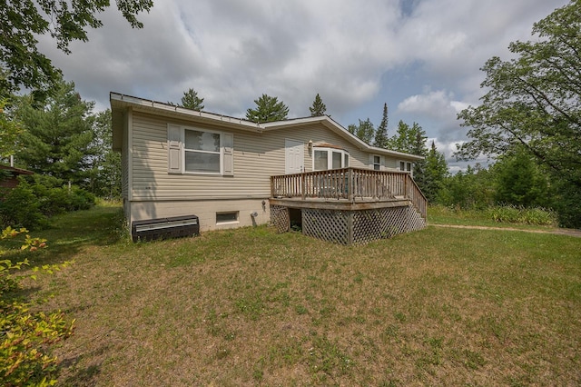 back of house featuring a deck and a yard