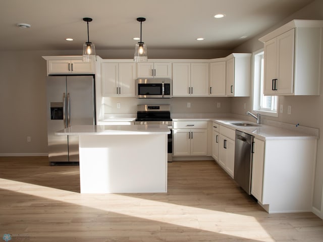 kitchen with pendant lighting, sink, stainless steel appliances, a center island, and white cabinets