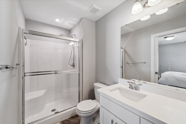 bathroom featuring vanity, toilet, tile patterned flooring, and a shower with door