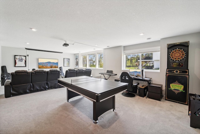 game room with a textured ceiling and light carpet