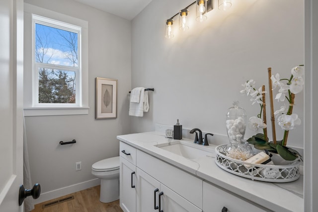 bathroom featuring toilet, hardwood / wood-style floors, and vanity