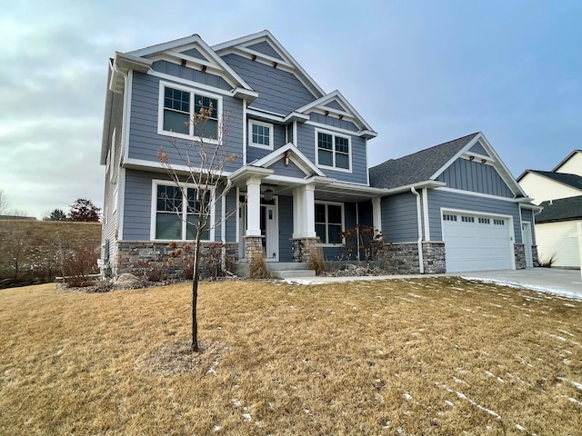 craftsman-style house featuring a porch, a garage, and a front yard