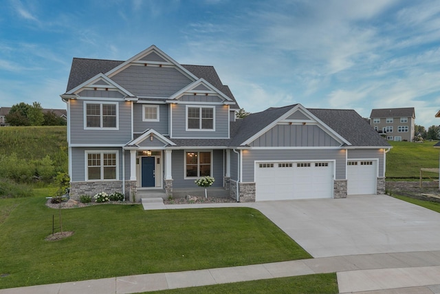 craftsman inspired home featuring a garage and a front yard