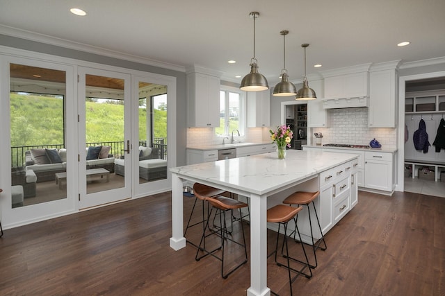 992 Southwell Enclave NE, Byron, MN 55920 - kitchen with a sink, decorative backsplash, a kitchen bar, appliances with stainless steel finishes, and white cabinetry