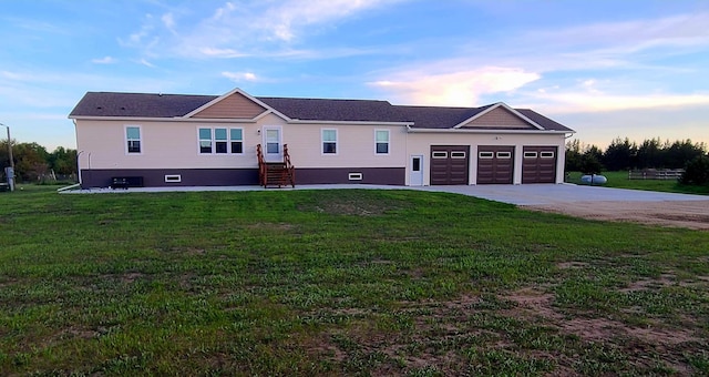 view of front of property with a garage and a lawn