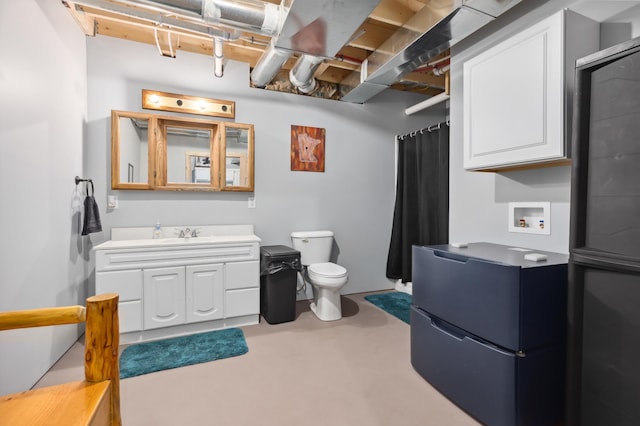 bathroom featuring vanity, concrete floors, and toilet