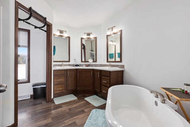 bathroom with vanity, hardwood / wood-style floors, and a tub