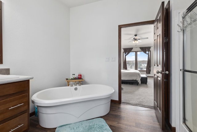 bathroom featuring hardwood / wood-style flooring, ceiling fan, vanity, and a tub