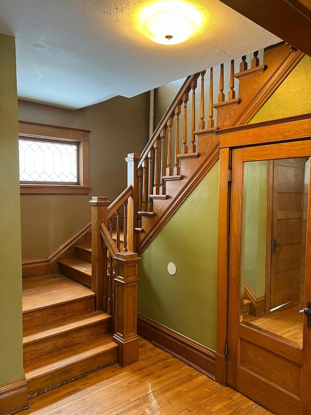 stairway featuring hardwood / wood-style flooring and a textured ceiling