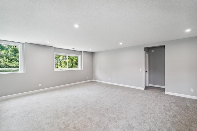 carpeted empty room with a textured ceiling