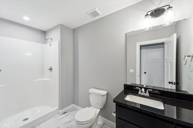 bathroom featuring toilet, vanity, and a shower