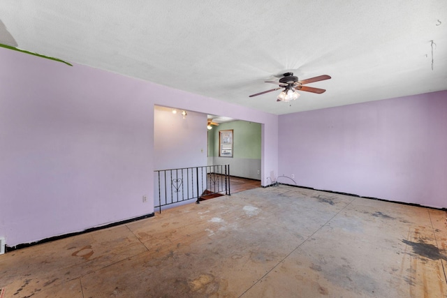 empty room featuring ceiling fan and a textured ceiling