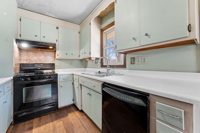 kitchen with sink, tasteful backsplash, black appliances, light hardwood / wood-style flooring, and white cabinets