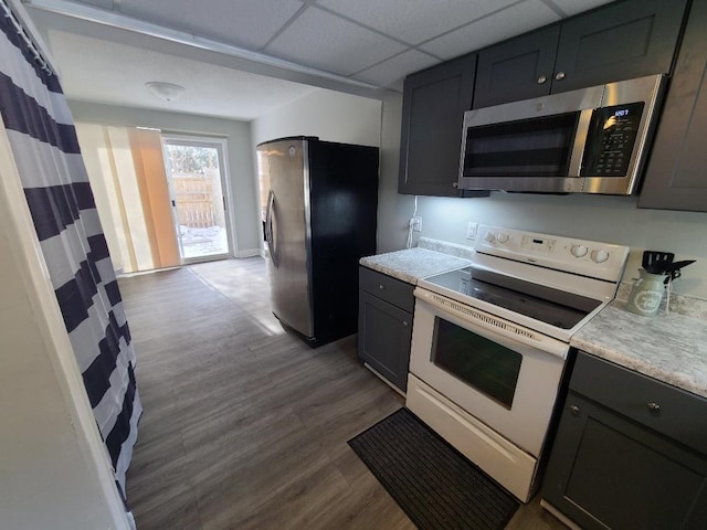 kitchen featuring dark wood-style floors, appliances with stainless steel finishes, light countertops, and a drop ceiling