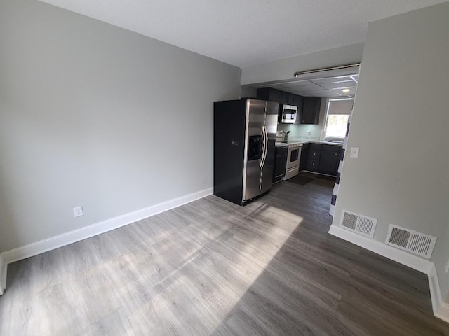 kitchen with appliances with stainless steel finishes, light countertops, visible vents, and baseboards