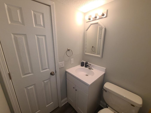 bathroom with toilet, a textured ceiling, and vanity